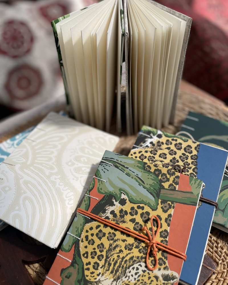 Handmade sketchbooks with patterned covers, one standing open.