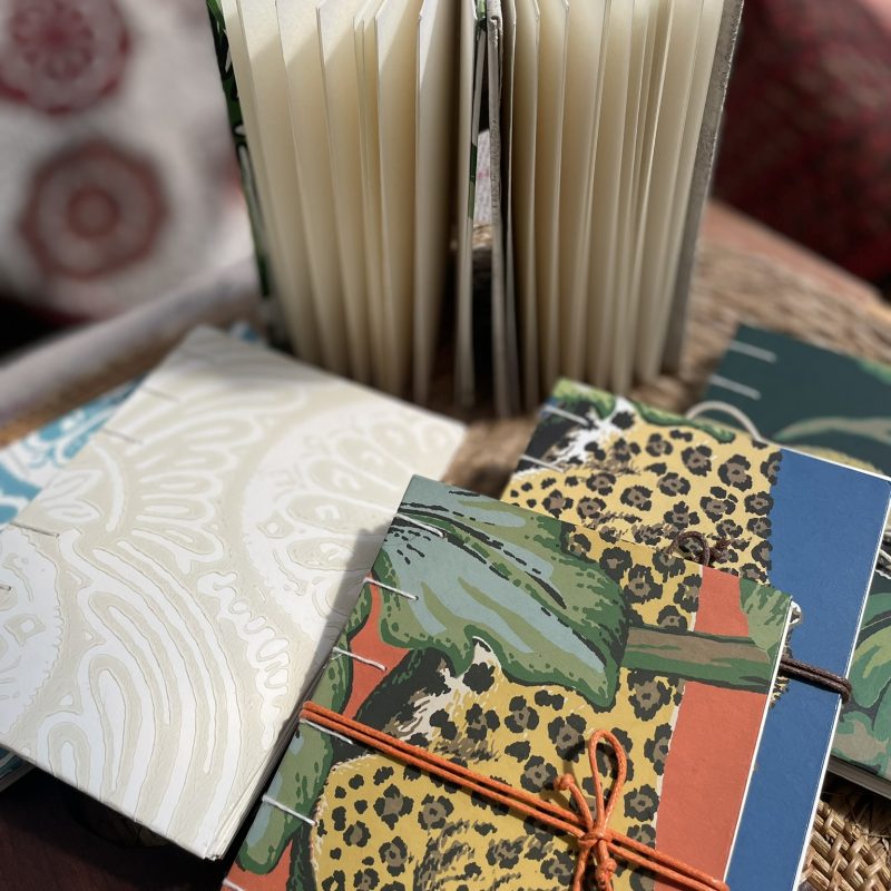Handmade sketchbooks with patterned covers, one standing open.